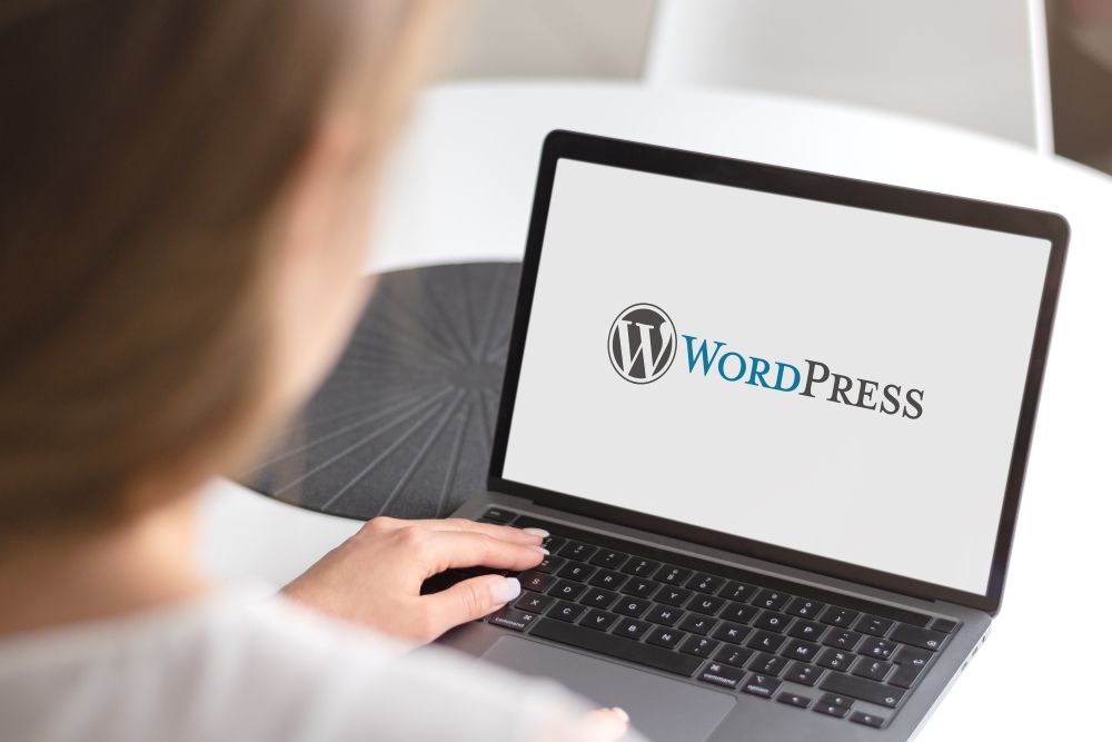 woman using a laptop with the wordpress logo on it